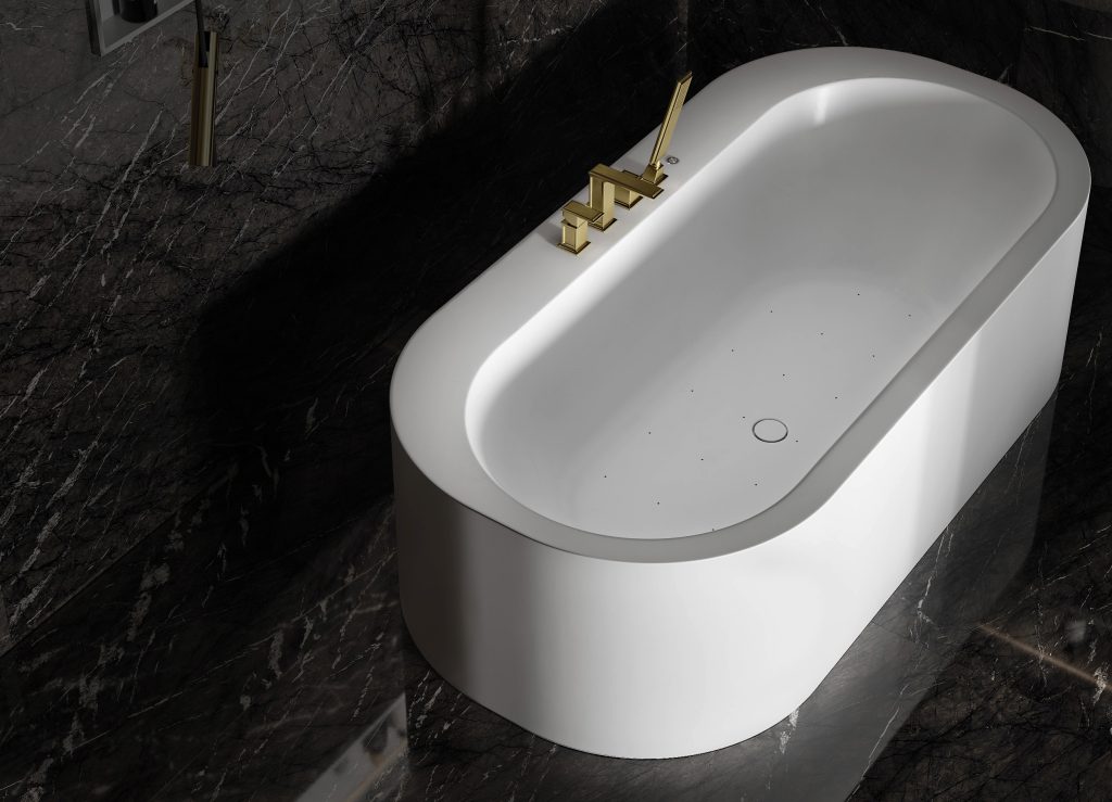 Freestanding MOMA Design bath with a brushed brass bath filler on a dark marble floor