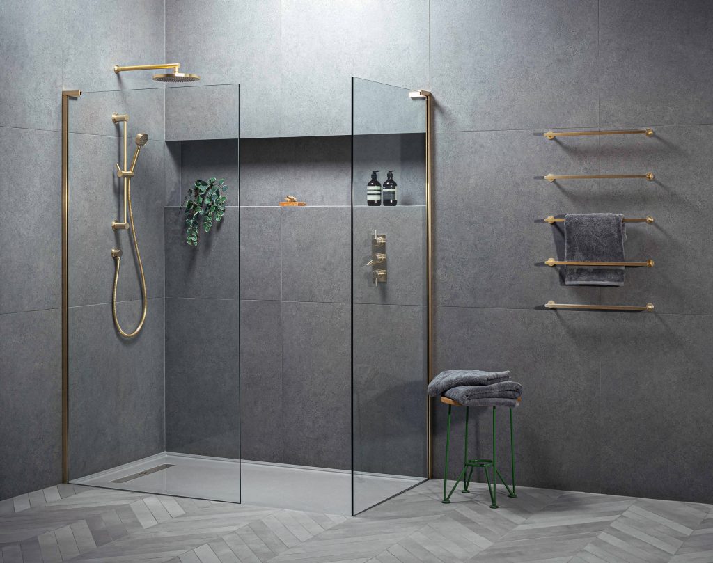 Walk-in shower with low-profile tray, linear drain, frameless glass and brushed brass fittings